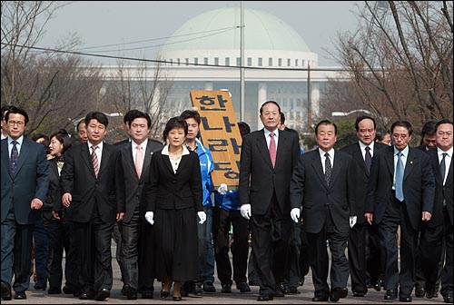 2004년 3월 24일 박근혜 의원이 한나라당 새대표로 선출된 다음날 박 신임 대표와 당직자들이 당 현판을 들고 천막 당사까지 걸어가고 있다.